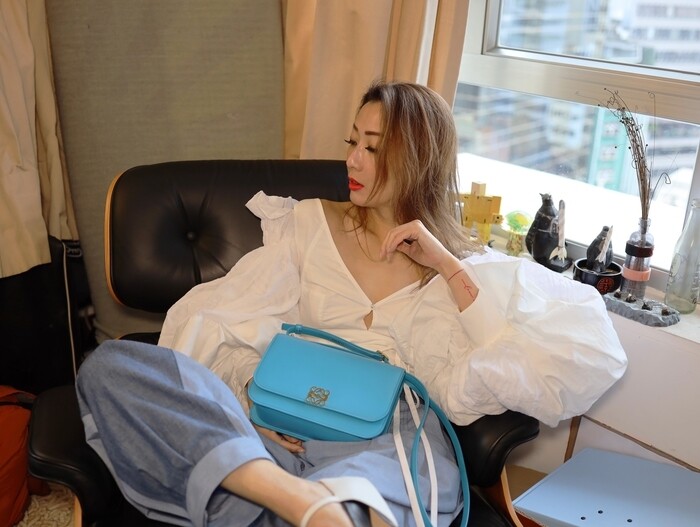 Sammi率先帶上彩藍色的Loewe Goya手袋，白色泡泡袖上衣和彩藍色手袋，帶如藍天